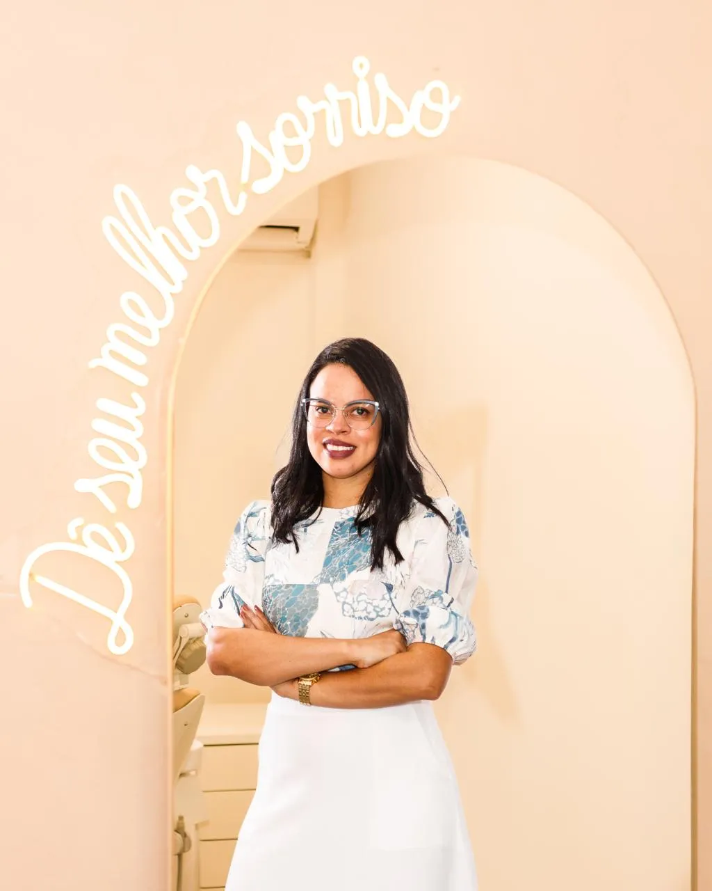 Dra. Ellane Talita sob o arco com o neon Dê o seu melhor sorriso